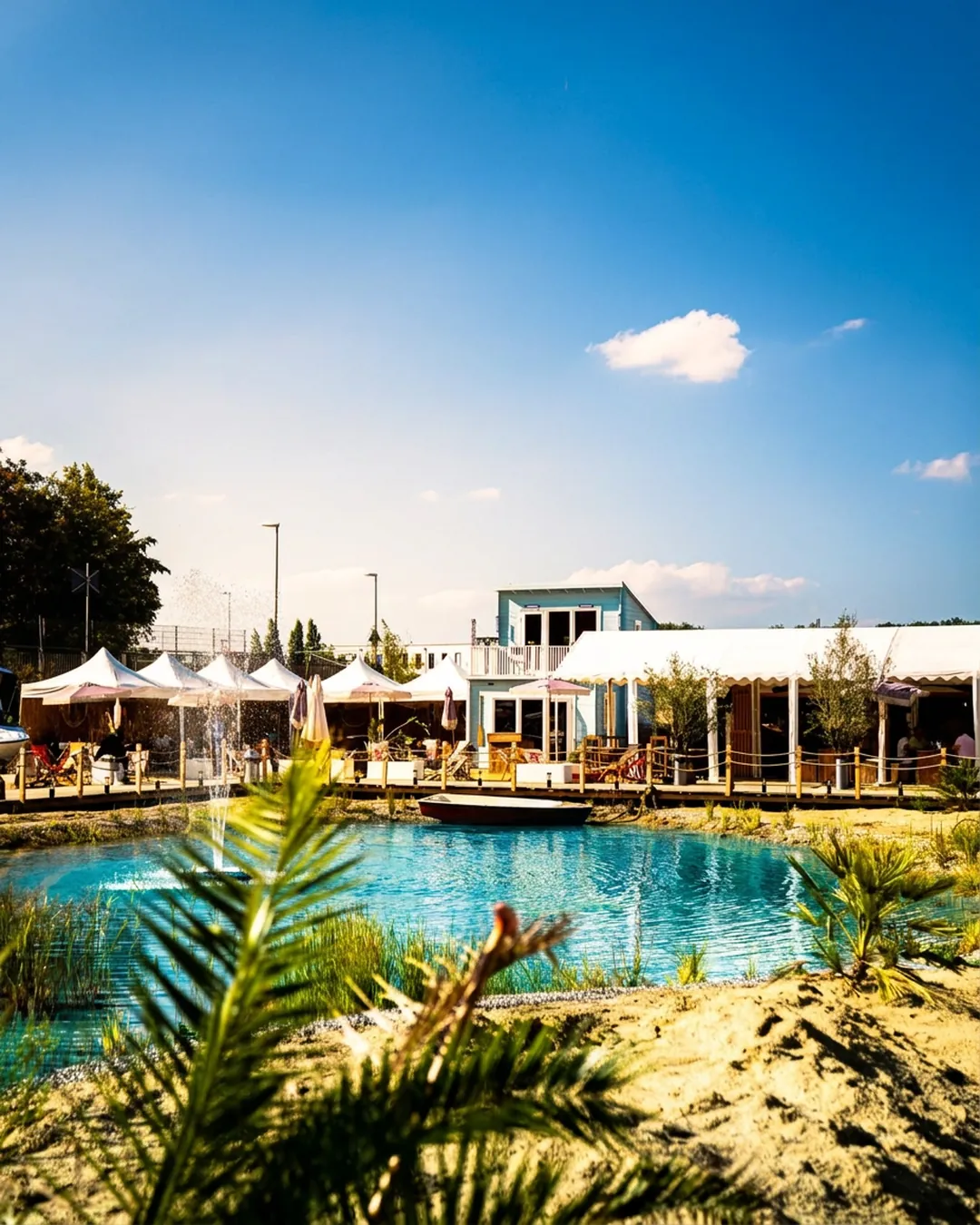 Badeteich mit türkisem Wasser, Sand und Palmen