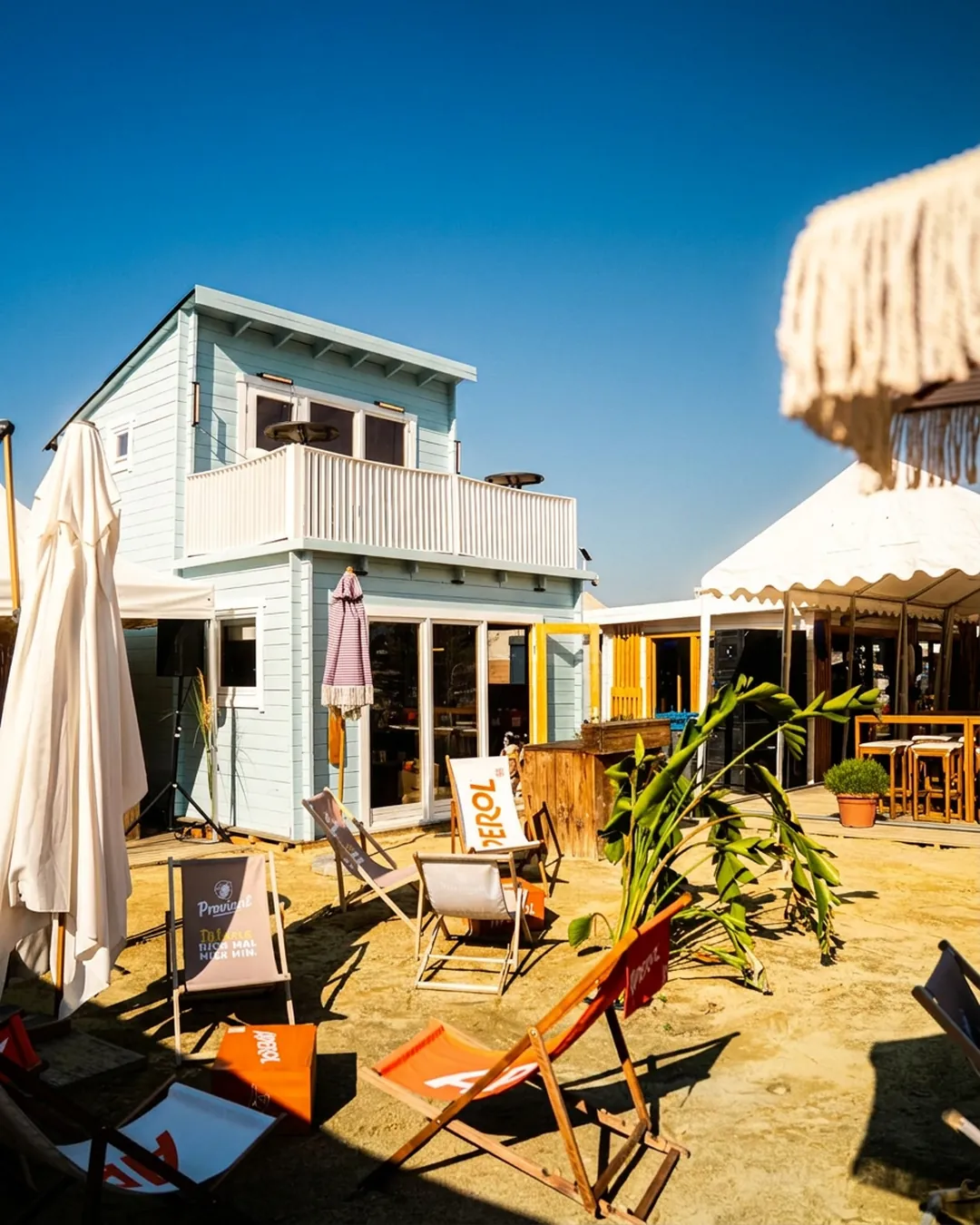 Liegestühle und Sonnenschirme im Sand